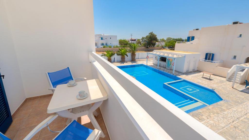 a balcony with a swimming pool and a table and chairs at Andreas Studio in Perissa