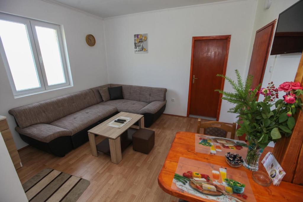 uma sala de estar com um sofá e uma mesa em Apartman Luka em Trebinje