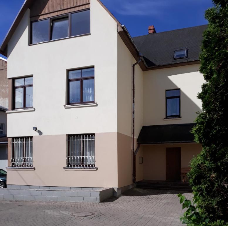 a white house with barred windows at Daugavpils City Centеr Apartment in Daugavpils