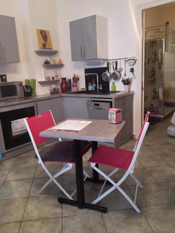 uma cozinha com uma mesa e duas cadeiras em L'appart em Reims