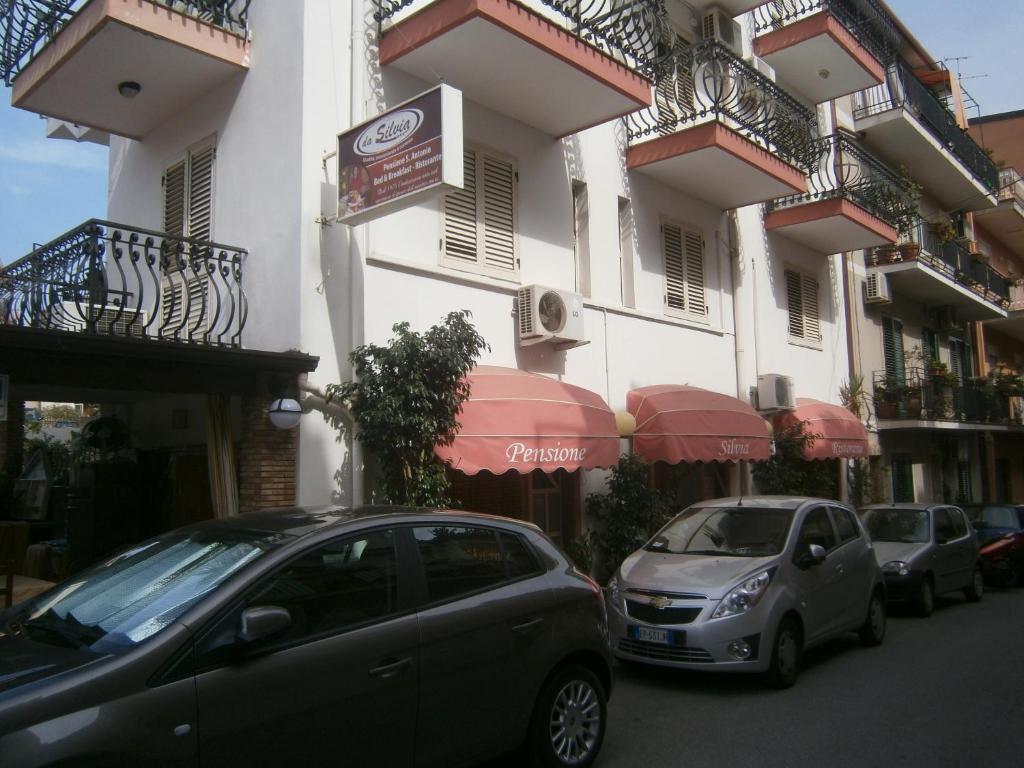 deux voitures garées devant un bâtiment dans l'établissement Pensione S. Antonio Ristorante Silvia, à Furci Siculo