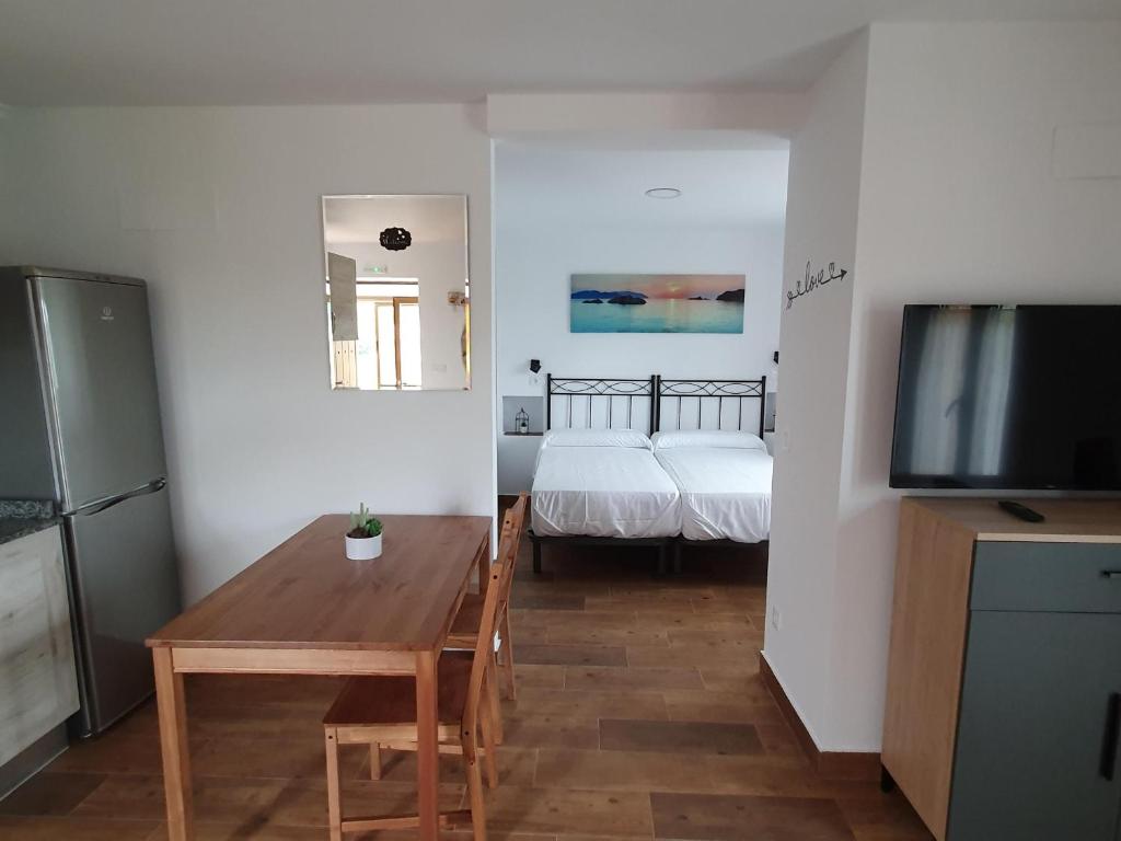 a room with a table and a television and a bed at VADOS - LA COLINA in Arnuero