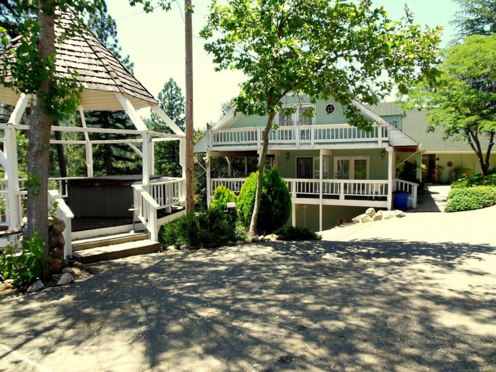 een wit huis met een veranda en een boom bij Berkshire Inn in Groveland