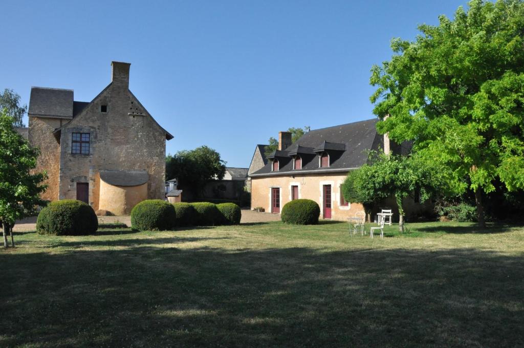 une vieille maison en pierre avec une grande cour dans l'établissement Manoir de la Croix Verte, à Le Bailleul