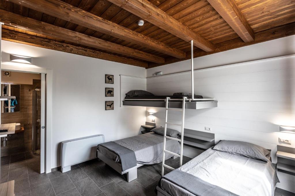 a bedroom with two bunk beds and a wooden ceiling at Miglio608 in Settimo Vittone
