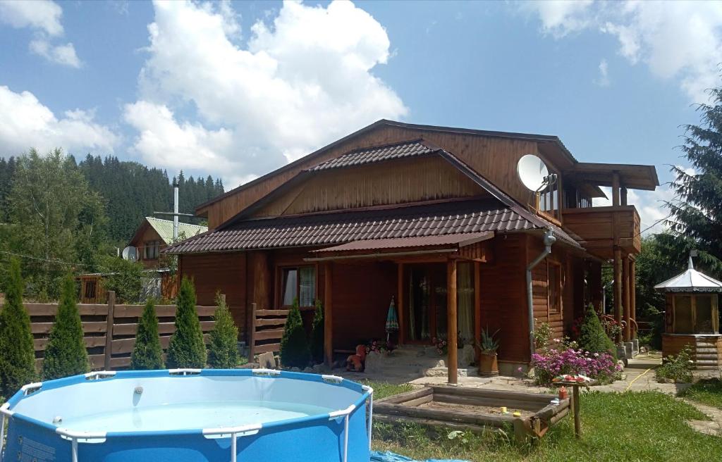 uma casa com uma banheira de hidromassagem em frente em Лісова пісня em Verkhovyna