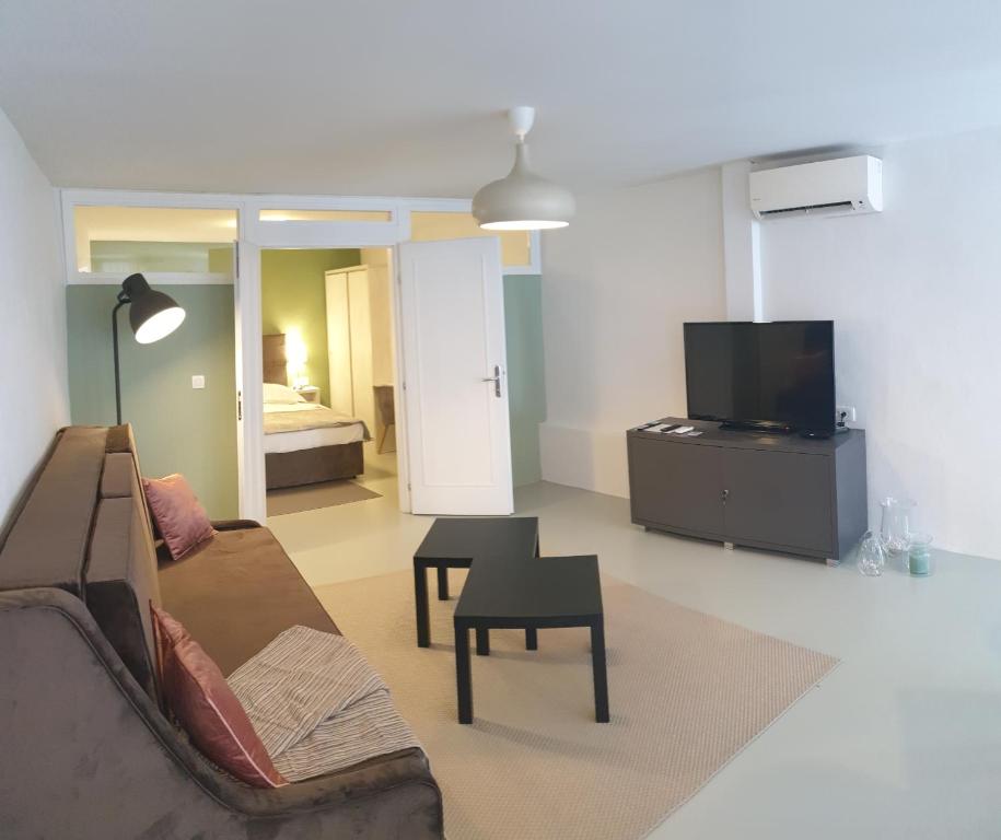 a living room with a couch and a table and a tv at Apartment Adriatico Eterno 2 in Rovinj