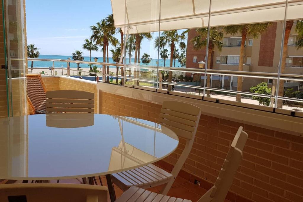 einen Tisch und Stühle auf einem Balkon mit Meerblick in der Unterkunft apartamento residencial brisamarina in Roquetas de Mar