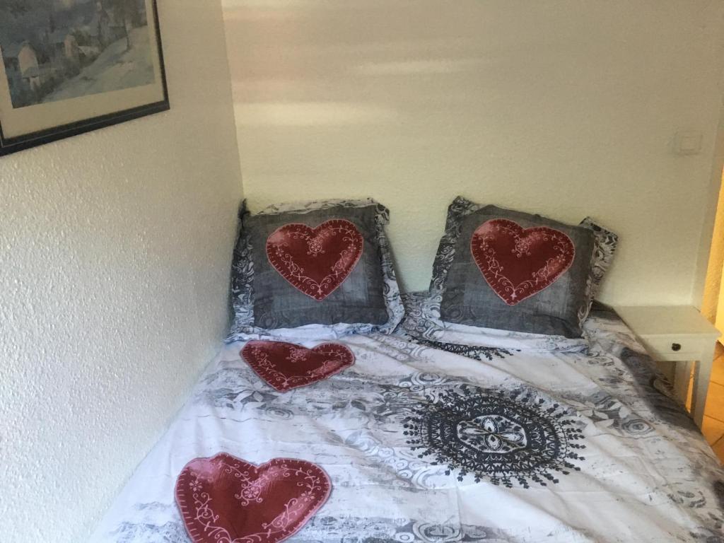 a bed with two pillows with hearts on it at appartement les deux alpes in Les Deux Alpes