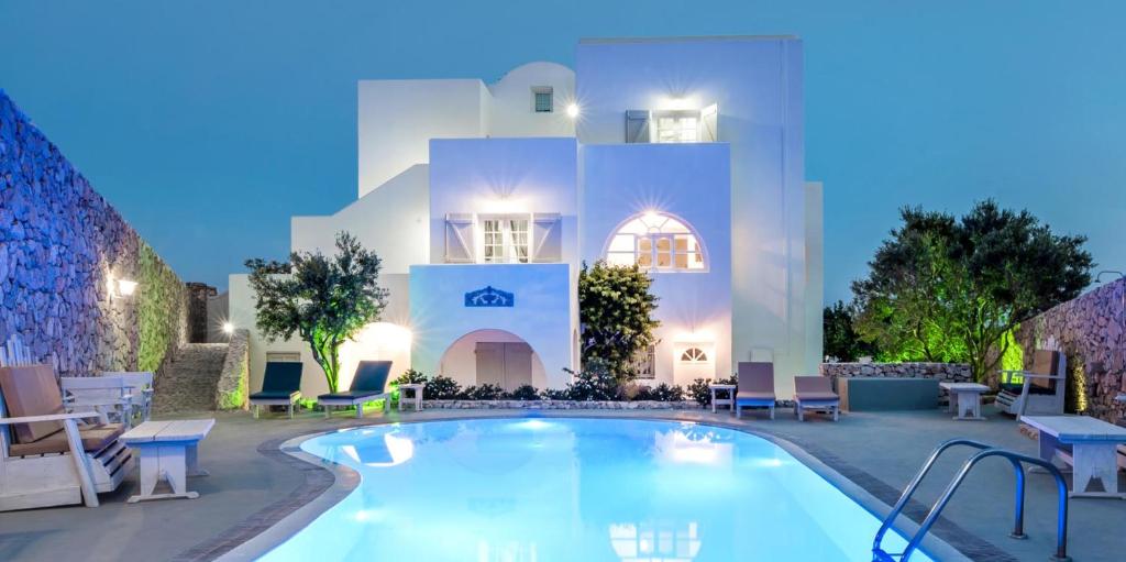 un hotel con piscina di fronte a un edificio di LavaRock Santorini a Perissa