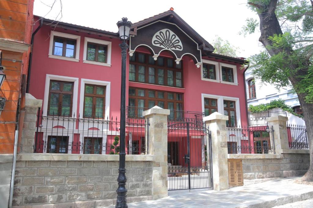 a red house with a black roof at HillHouse Plovdiv in Plovdiv