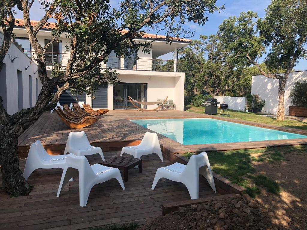 une arrière-cour avec une piscine, des chaises et une maison dans l'établissement VILLA LECCI E MARE, à Olmucciu