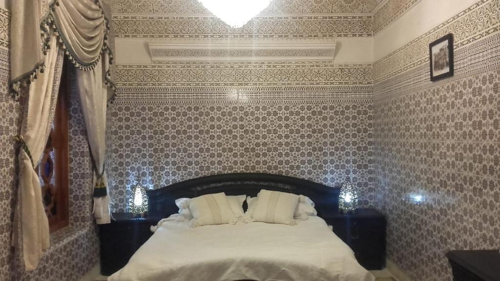 馬拉喀什的住宿－Riad Oum Ellkhir，壁纸客房内的一间卧室配有一张床