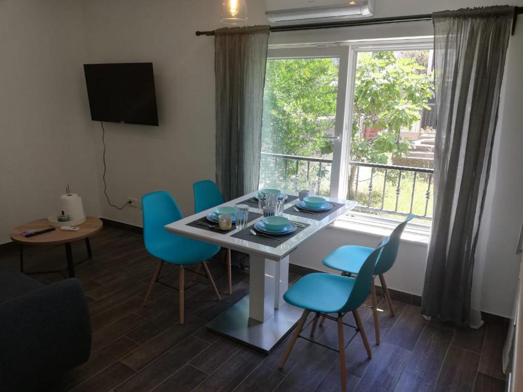 jadalnia ze stołem i krzesłami oraz oknem w obiekcie Apartment Simply Rodin w mieście Kaštela