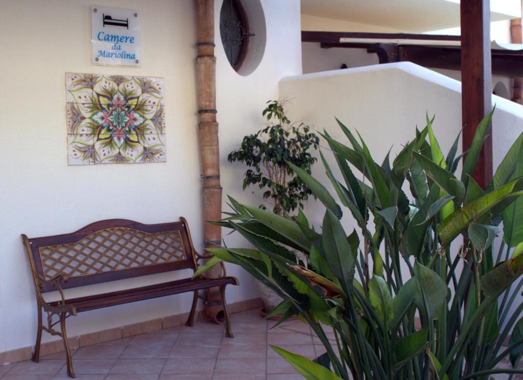 マカリにあるCamere da Mariolinaの植物の並ぶ部屋の隅のベンチ