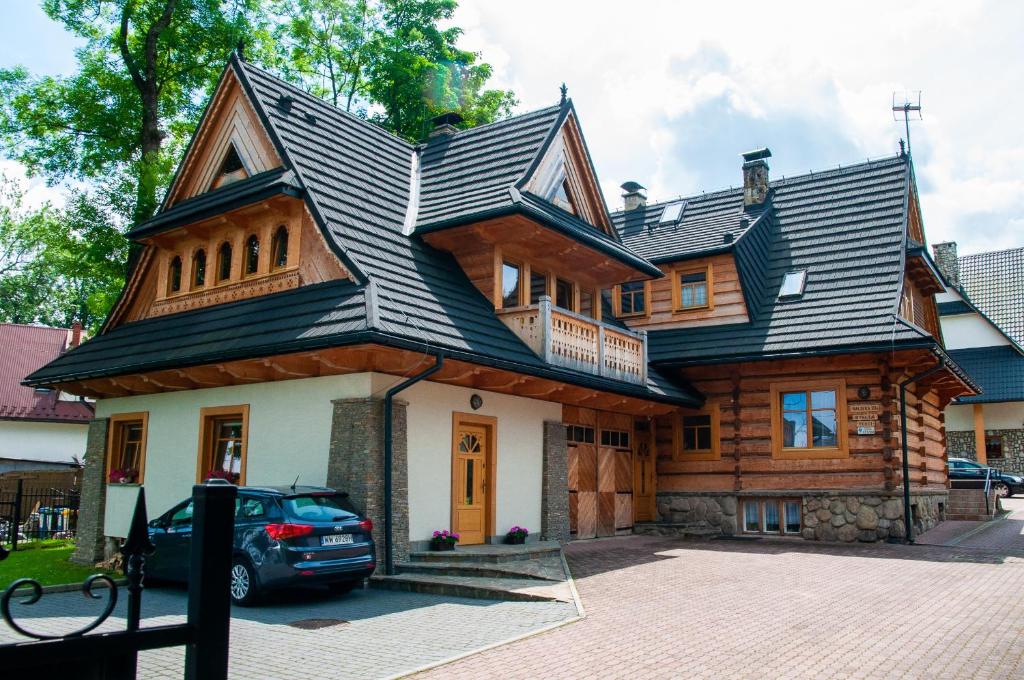 una gran casa de madera con techo negro en Willa Pod Nosalem I en Zakopane