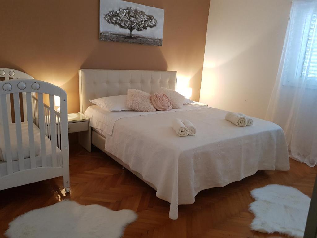 sypialnia z białym łóżkiem i 2 ręcznikami w obiekcie Apartment Lava w mieście Kaštela