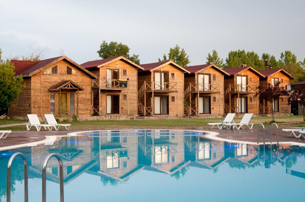 a row of lodges with a pool in front of it at Agva Gizemli Nehir Hotel in Ağva