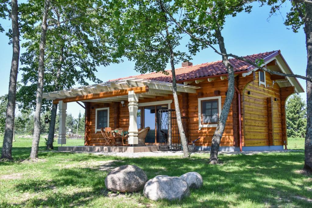 uma cabana de madeira na floresta com árvores em Mekų vila em Degučiai