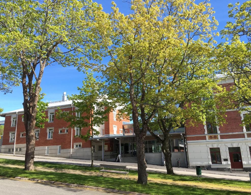 um edifício de tijolos com árvores em frente em EC-Hostel em Vaasa