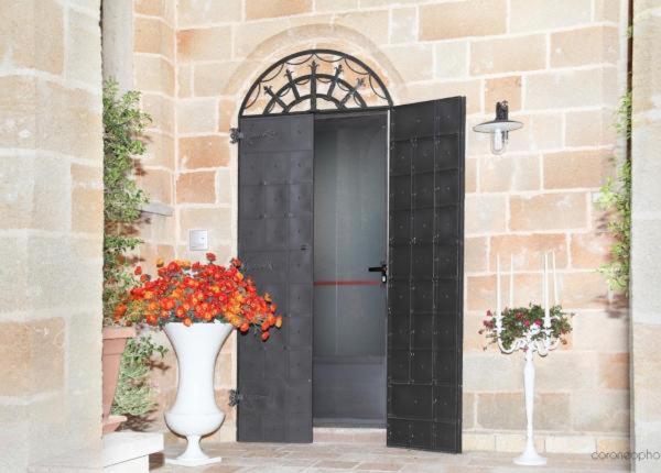 a black door with two vases with flowers in front of it at Vico Cavour in Veglie