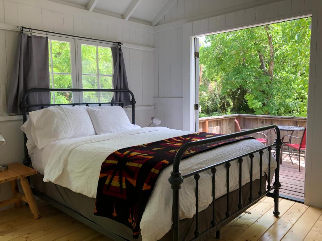 a bedroom with a bed and a large window at Johnson's Beach Cabins and Campground in Guerneville