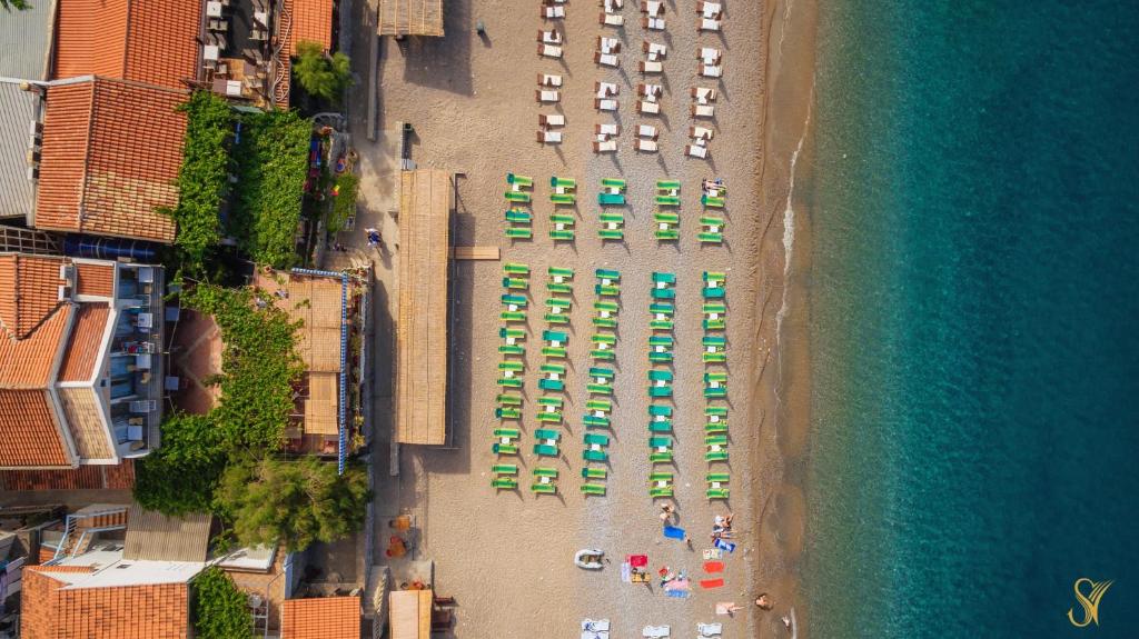 an aerial view of a beach with umbrellas and chairs at Hotel Savojo in Petrovac na Moru