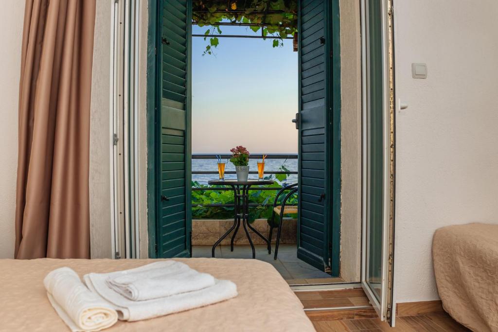 a room with a view of the ocean and a table at Hotel Savojo in Petrovac na Moru