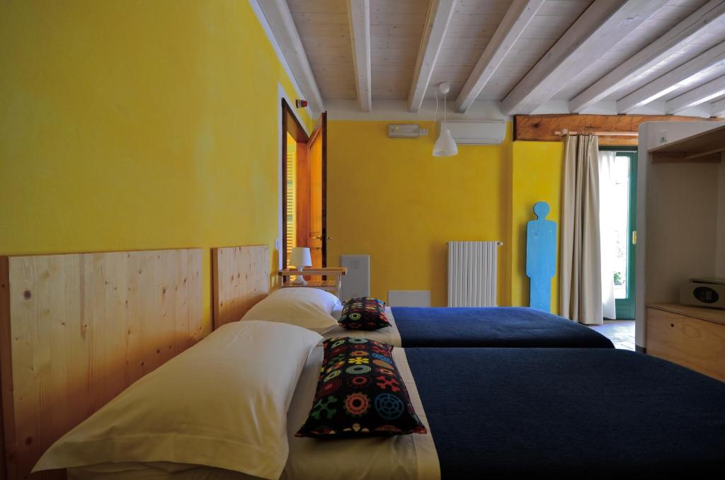 1 Schlafzimmer mit 3 Betten mit blauen und gelben Wänden in der Unterkunft A Casa Di Mìnola in 