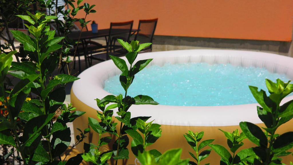 a jacuzzi tub in a garden with a table at Apartment Gamma with hydromassage mini pool near Split in Žrnovnica