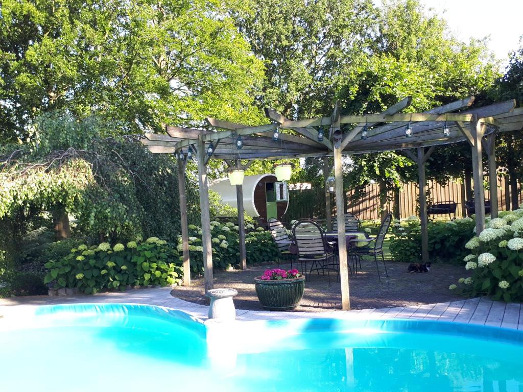 un pergolato e una piscina in un cortile di Irish Bowtop op het platteland van Huize Ouwervelden a Wouwsche Plantage