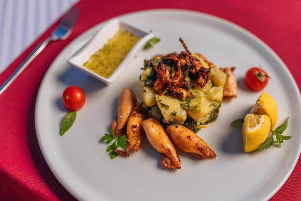 a plate of food with potatoes and vegetables on a table at Hotel Savojo in Petrovac na Moru