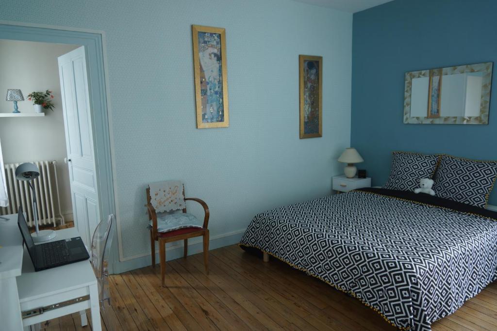 a bedroom with blue walls and a bed and a chair at Studio privatisé avec terrasse dans maison de charme angevine in Angers