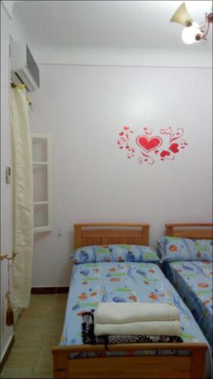 a bedroom with two beds and a clock on the wall at Al-Madina Tower Apartments in Marsa Matruh