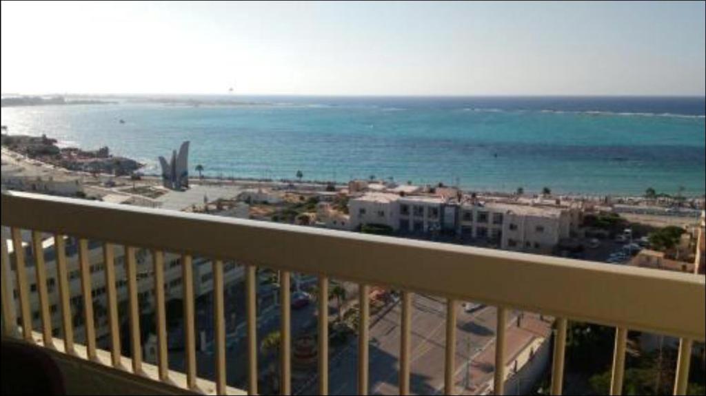 a balcony with a view of the beach and the ocean at Al-Madina Tower Apartments in Marsa Matruh