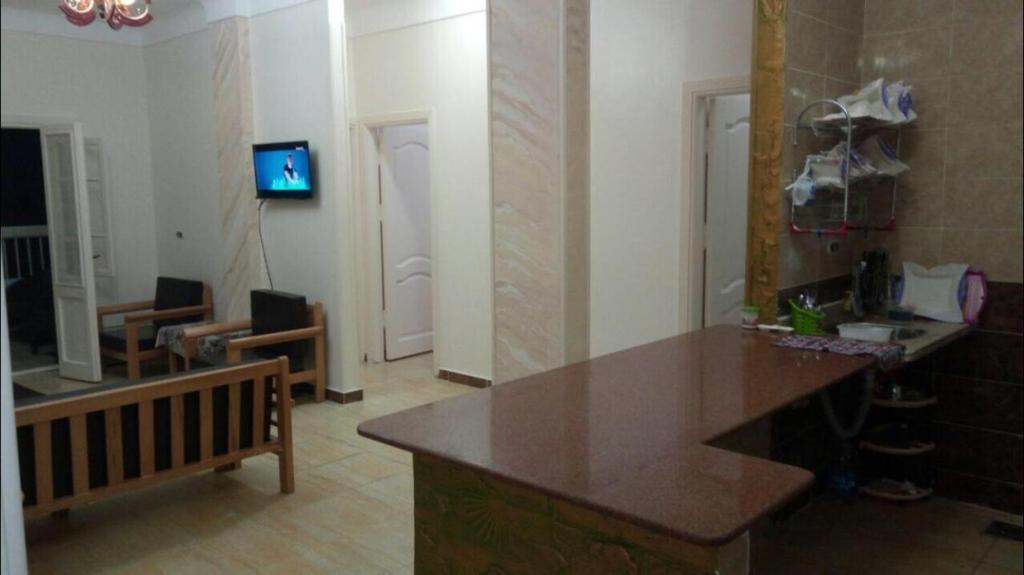 a living room with a kitchen with a counter top at Al-Madina Tower Apartments in Marsa Matruh