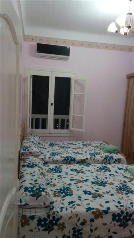 a bedroom with a bed with a floral comforter at Al-Madina Tower Apartments in Marsa Matruh