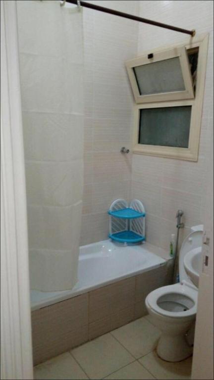 a bathroom with a toilet and a tub and a sink at Al-Madina Tower Apartments in Marsa Matruh