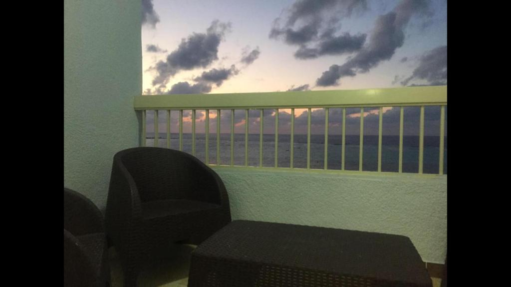a room with a chair and a window with clouds at Al-Madina Tower Apartments in Marsa Matruh