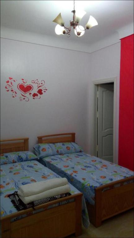 a bedroom with a bed and a ceiling fan at Al-Madina Tower Apartments in Marsa Matruh