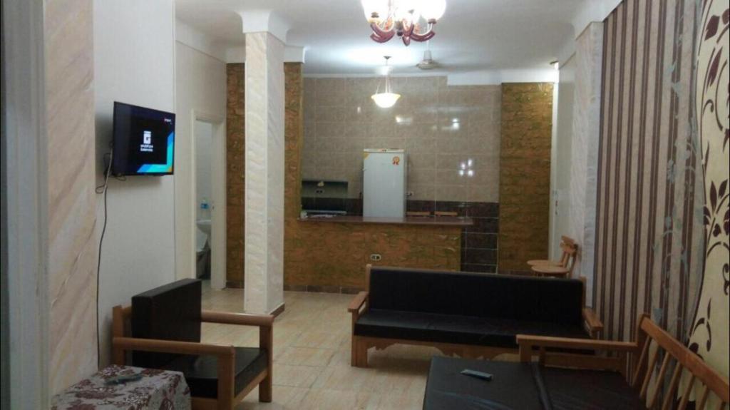 a living room with a tv and a table and chairs at Al-Madina Tower Apartments in Marsa Matruh