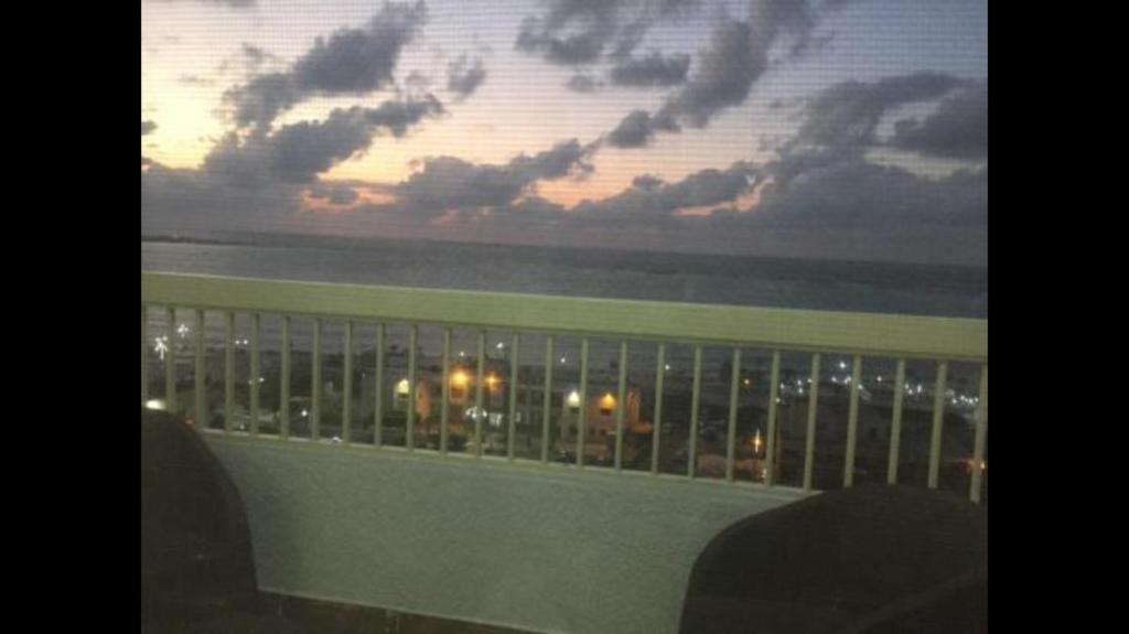 a view of the ocean from a balcony at sunset at Al-Madina Tower Apartments in Marsa Matruh