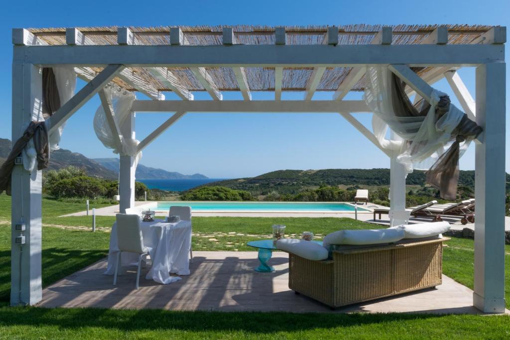 a white gazebo with a table and chairs at Villa Dama luxury in Alghero