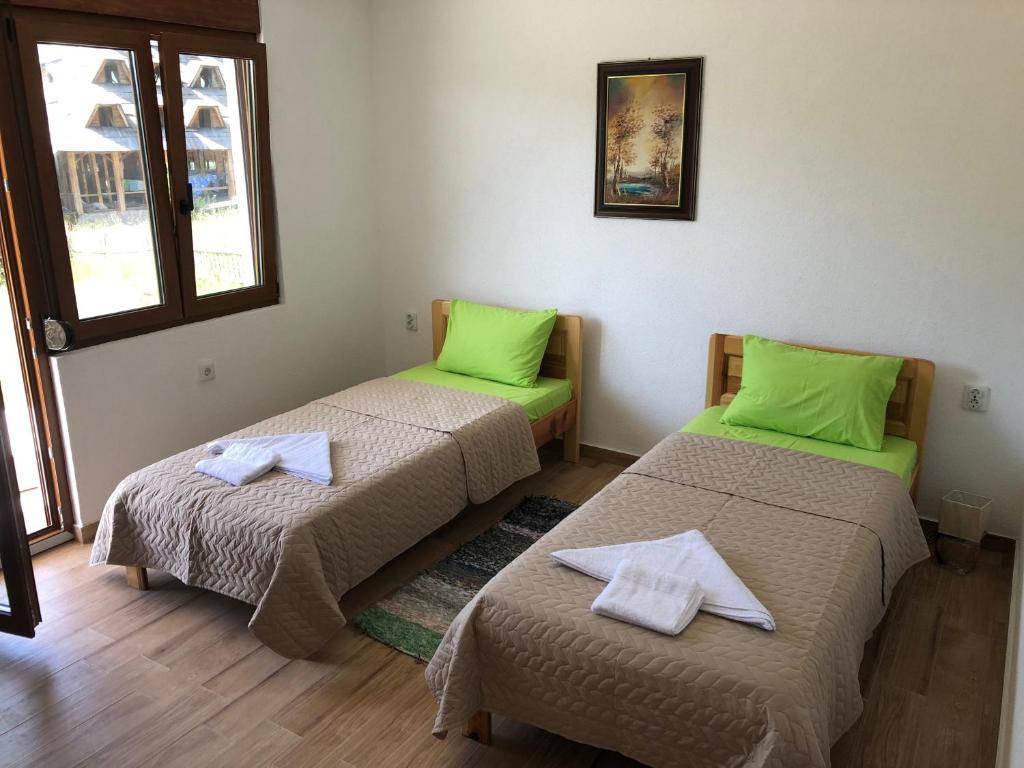 two beds in a room with green pillows on them at Visitor Yard in Plav