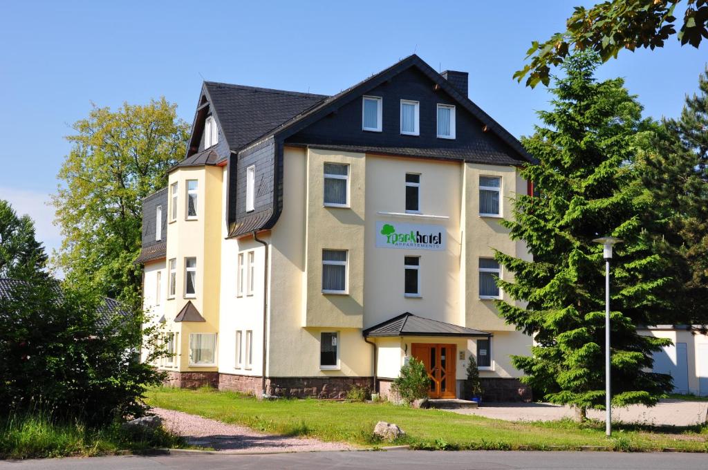 オーバーホーフにあるKonsumhotel am Park - Nebenhaus Berghotel Oberhof - nur Übernachtungの黒屋根の白い大きな建物