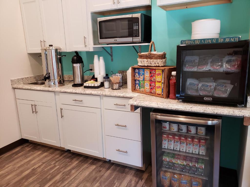 
a kitchen with a stove, microwave, and refrigerator at Beach Bum Inn in Ocean City
