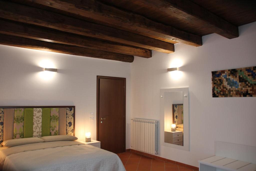 a bedroom with a bed and a mirror and lights at Le Vie Mediterranee in Torre di Ruggiero