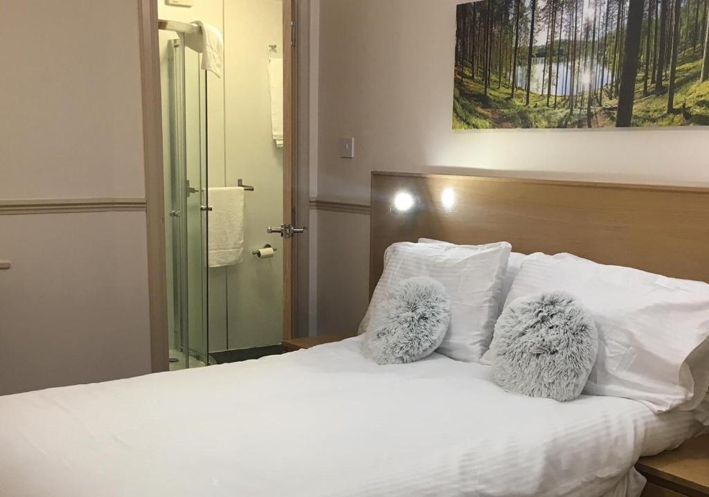 Una cama con dos animales de peluche encima. en Terra Nova Hotel, en Aberdeen