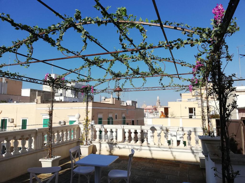 uma varanda com mesas, cadeiras e flores em Al Rosa Antico em Monopoli