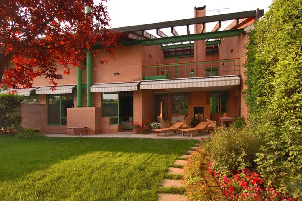 ein großes Backsteingebäude mit einer Terrasse und einem Hof in der Unterkunft Villa delle Ortensie in Tavagnacco